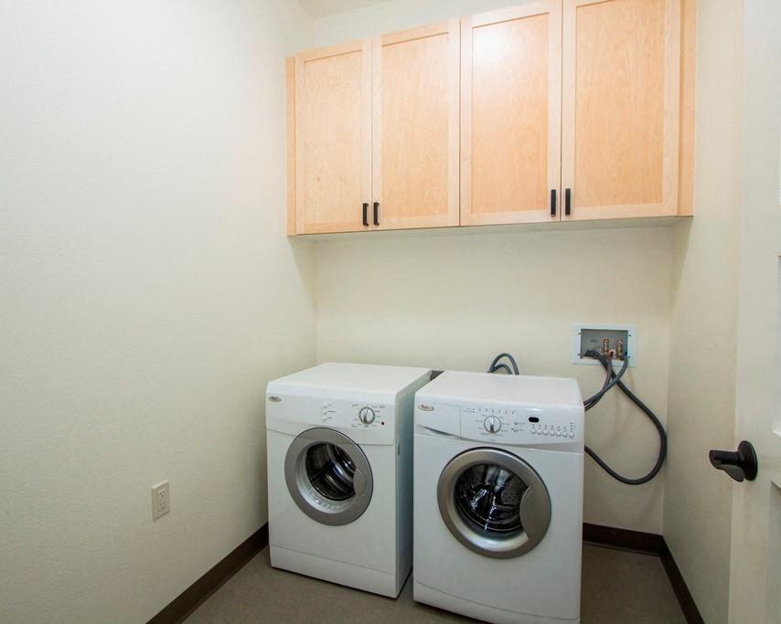 a washer and dryer in a laundry room with cabinets